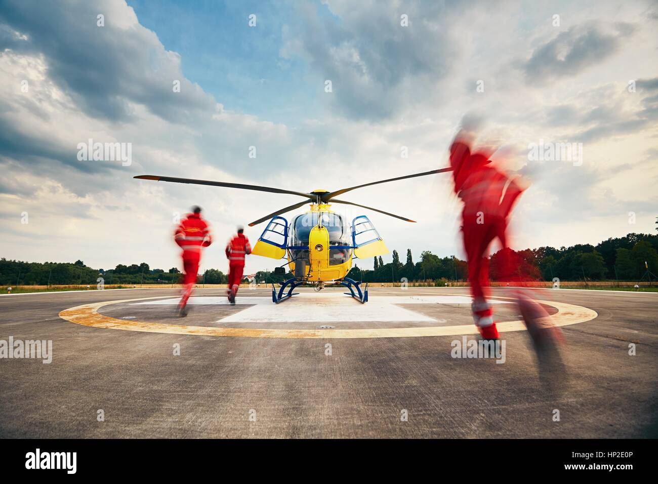 Alarme pour l'air rescue service. Équipe de sauveteurs (paramédic, médecin et pilote) fonctionnant à l'hélicoptère sur l'héliport. Banque D'Images