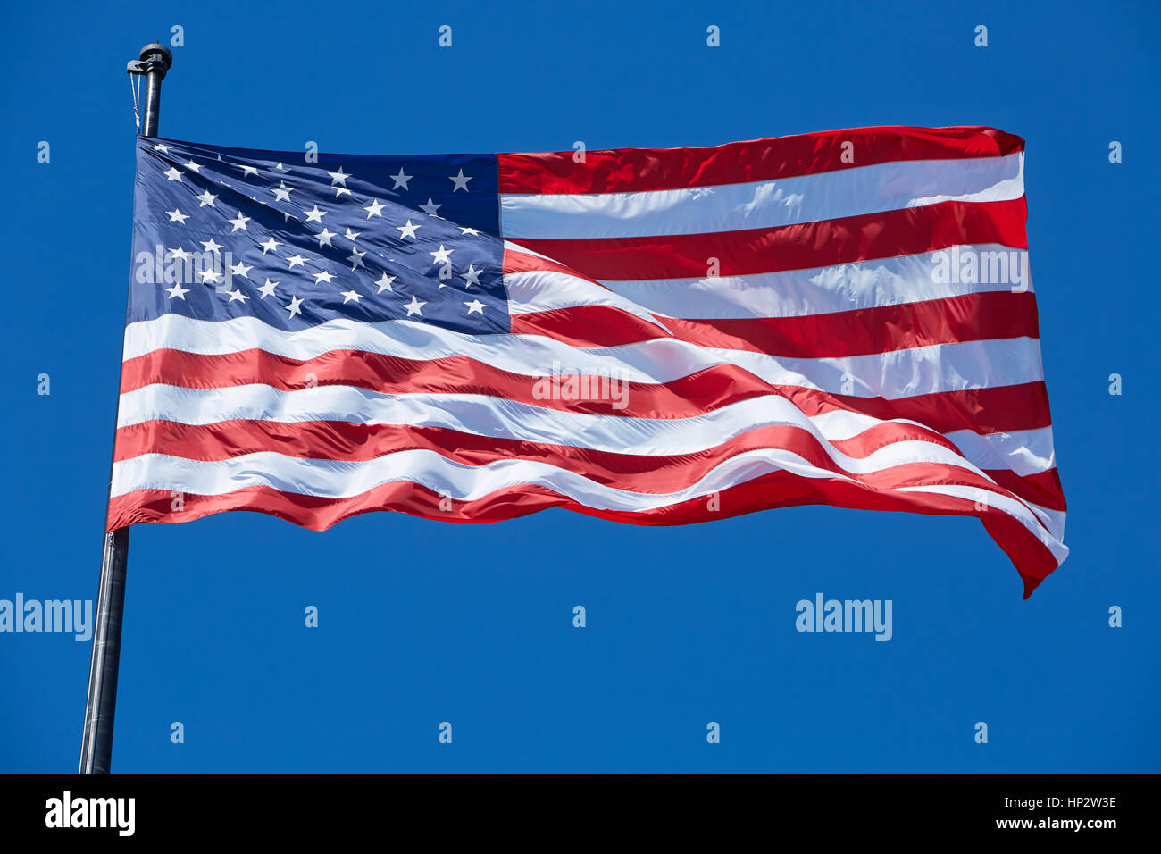 Drapeau américain USA ou au vent sur ciel bleu clair Banque D'Images