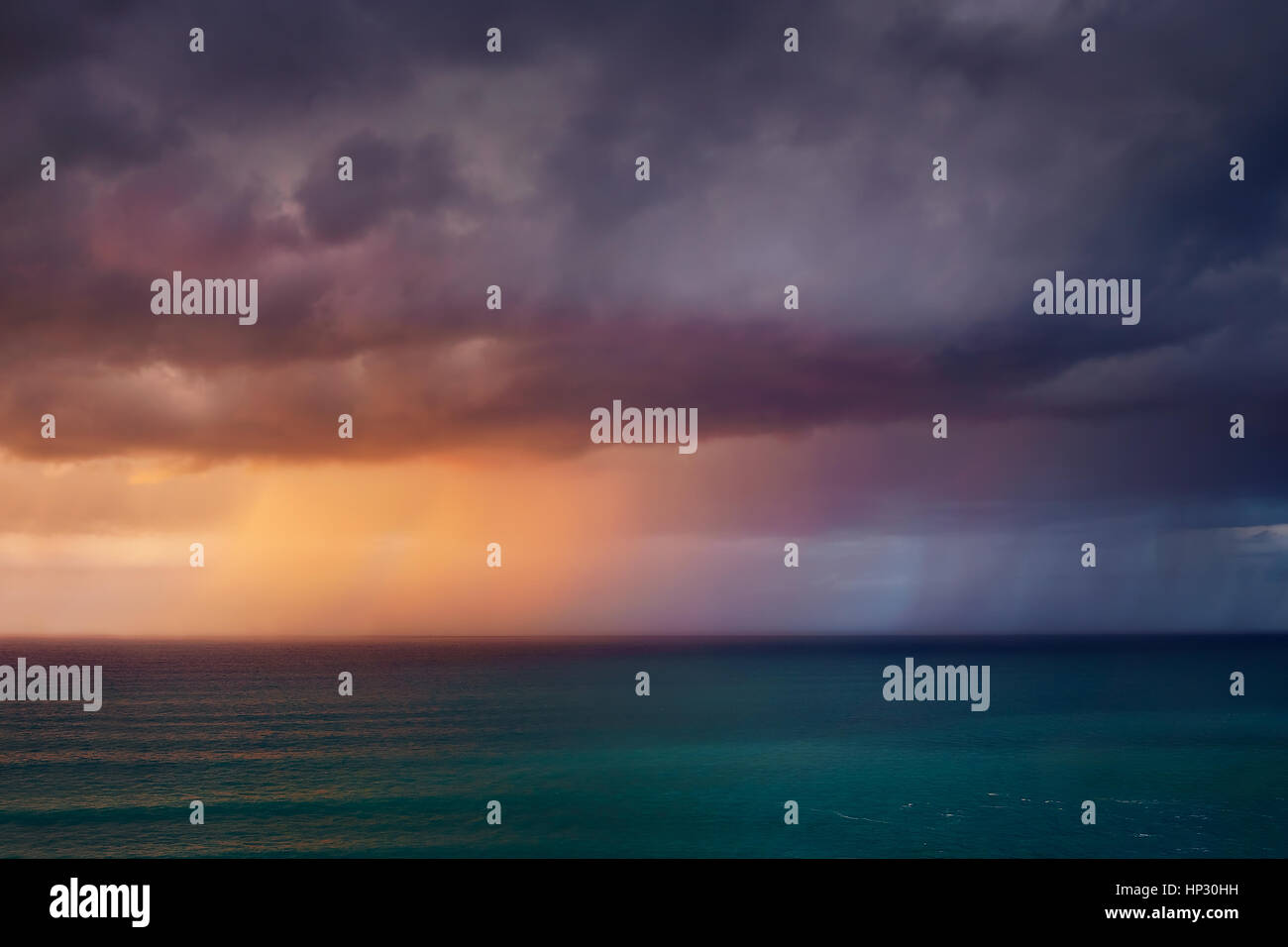 Pluie dans la mer au coucher du soleil Banque D'Images