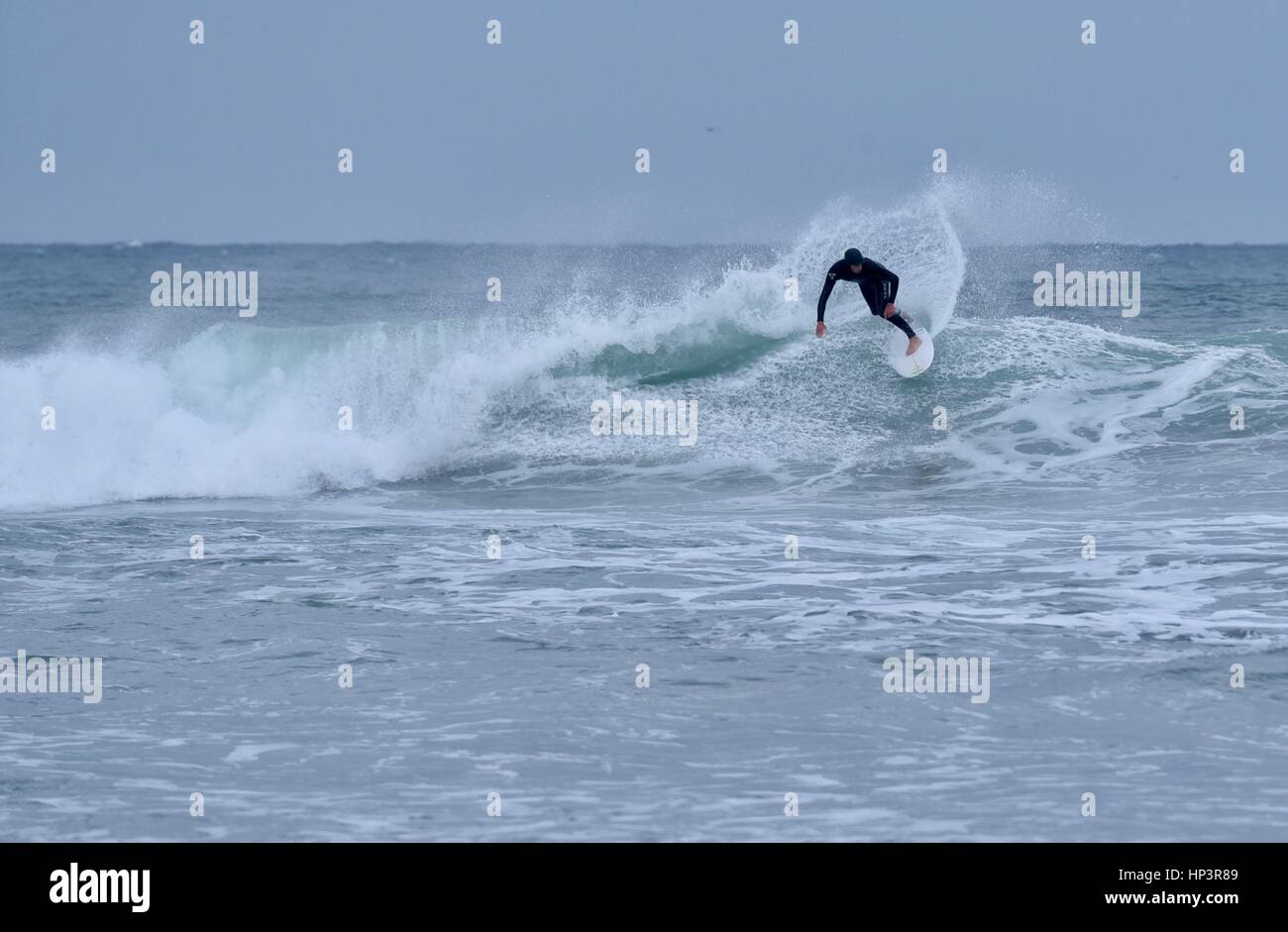 Surfer sur la vague en dépit des conditions météorologiques, et des vagues de surf haute rive sur accident de Mission Beach, San Diego, Californie. Banque D'Images