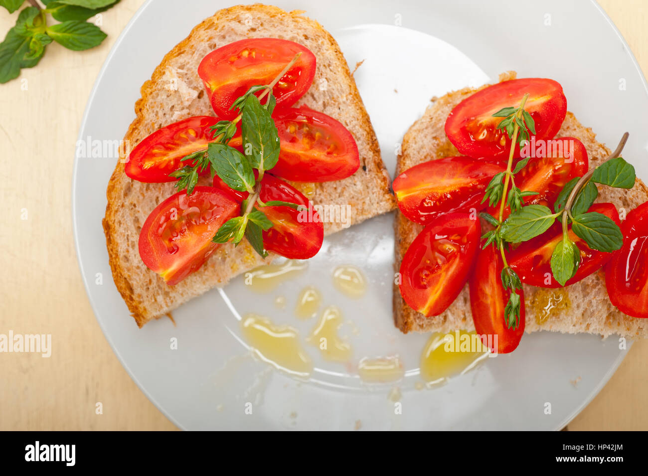 Bruschetta aux tomates italiennes avec le thym et les feuilles de menthe Banque D'Images