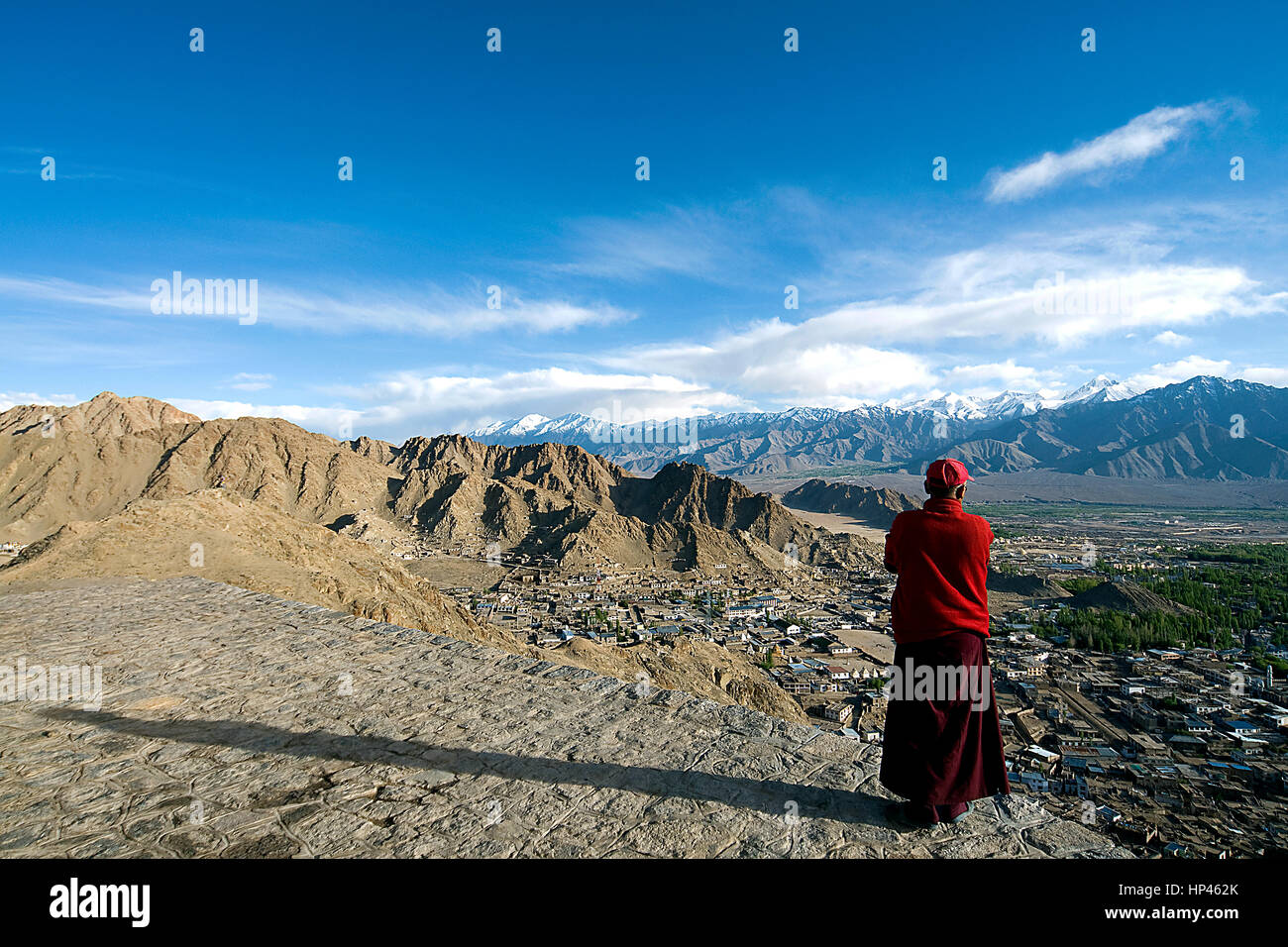 Un moine bouddhiste au monastère de Namgyal Tsemo à Leh en ville le soir avec grande ombre, ciel flou, quelques nuages, vaste paysage Banque D'Images