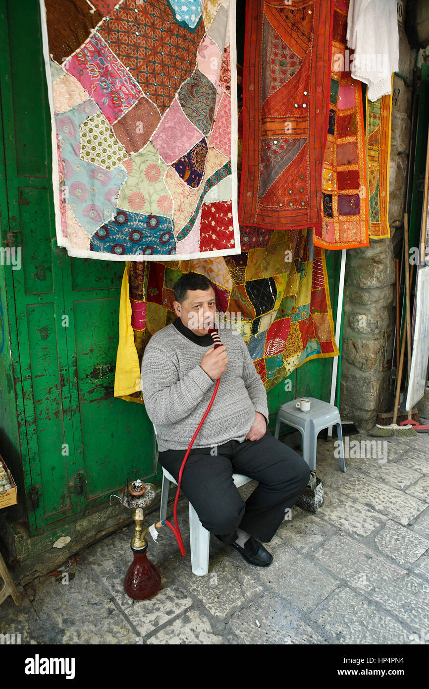 Dealer assis sur une chaise en face de son magasin dans la vieille ville et  fumer une Shisha, Jérusalem, Israël Photo Stock - Alamy