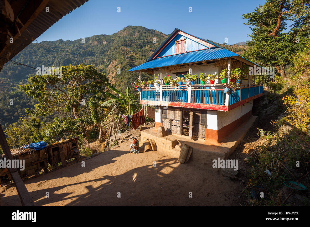 TAPLEJUNG, NÉPAL - 13 décembre 2016 : Femme assise en face d'une maison traditionnel Newari, 13 décembre 2016 à Taplejung, Népal Banque D'Images