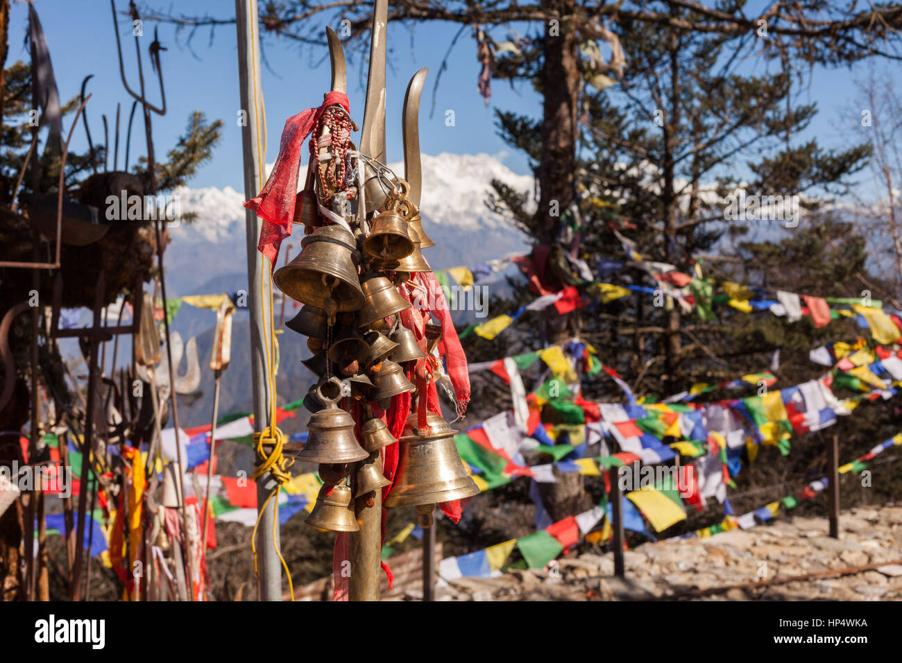 Cloches suspendues à trishula et les drapeaux de prières, pathivara devi temple, taplejung, Népal Banque D'Images