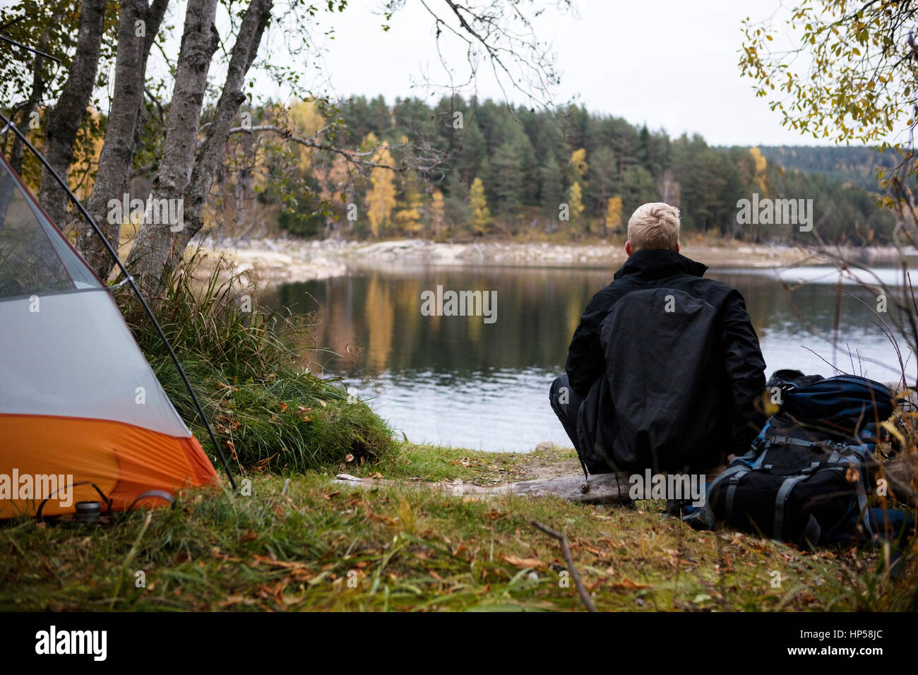 Backpacker mâle en profitant de la vue du lac au camping Banque D'Images
