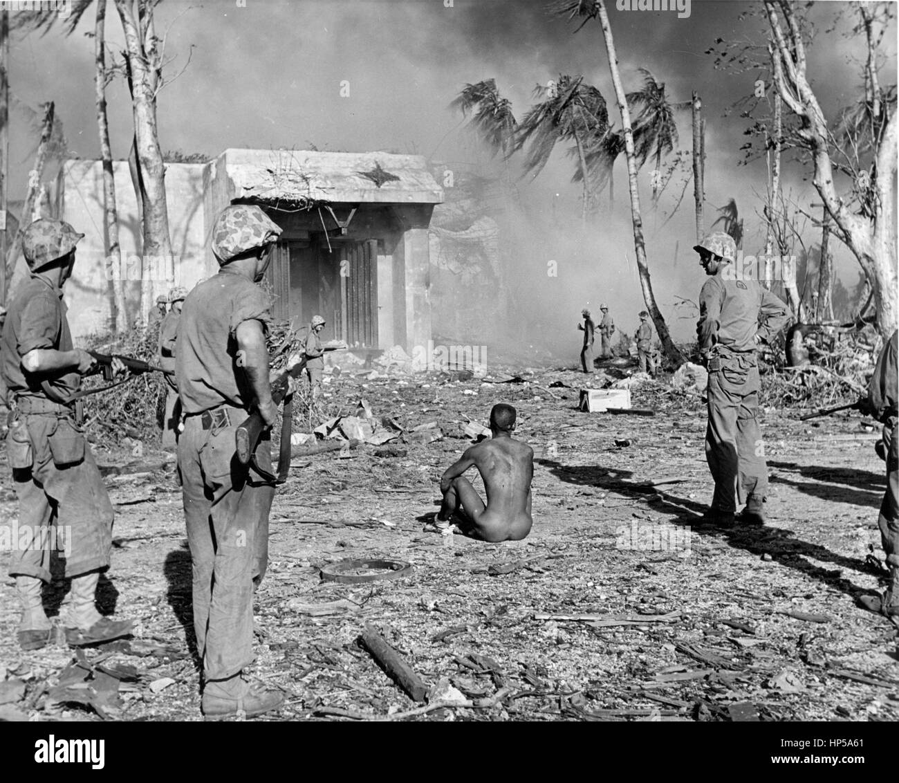 Les marines DES ÉTATS-UNIS dans la deuxième Guerre mondiale tiennent un prisonnier japonais alors qu'ils avancent après un bombardement de 4 jours d'une île du Pacifique non identifiée. années 1940. Pour voir mes images vintage connexes, recherchez: Prestor vintage WW II arme Banque D'Images