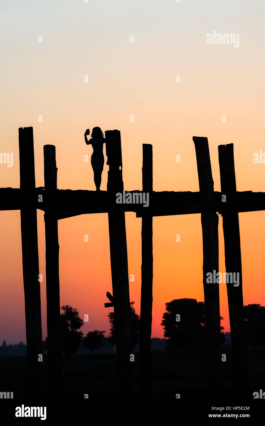 Silhouette d'une jeune femme tenant un sur selfies pont U Bein, Amarapura, Mandalay, Myanmar, près de. Banque D'Images