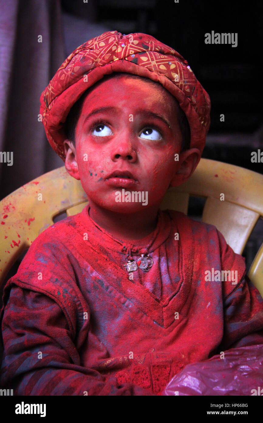 Portrait d'enfant couverte de couleurs rouges pendant Holi Holi célébration à Vrindavan, Inde Banque D'Images