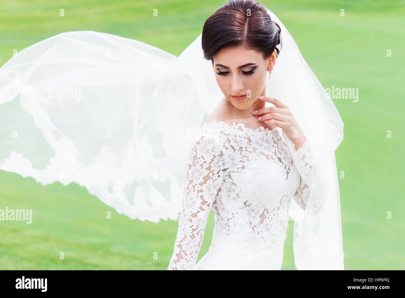 Portrait de belle mariée robe de mariage en voletant avec voile sur le champ vert du club de golf. Mariée avec long voile voletant dans le vent. Nous Banque D'Images