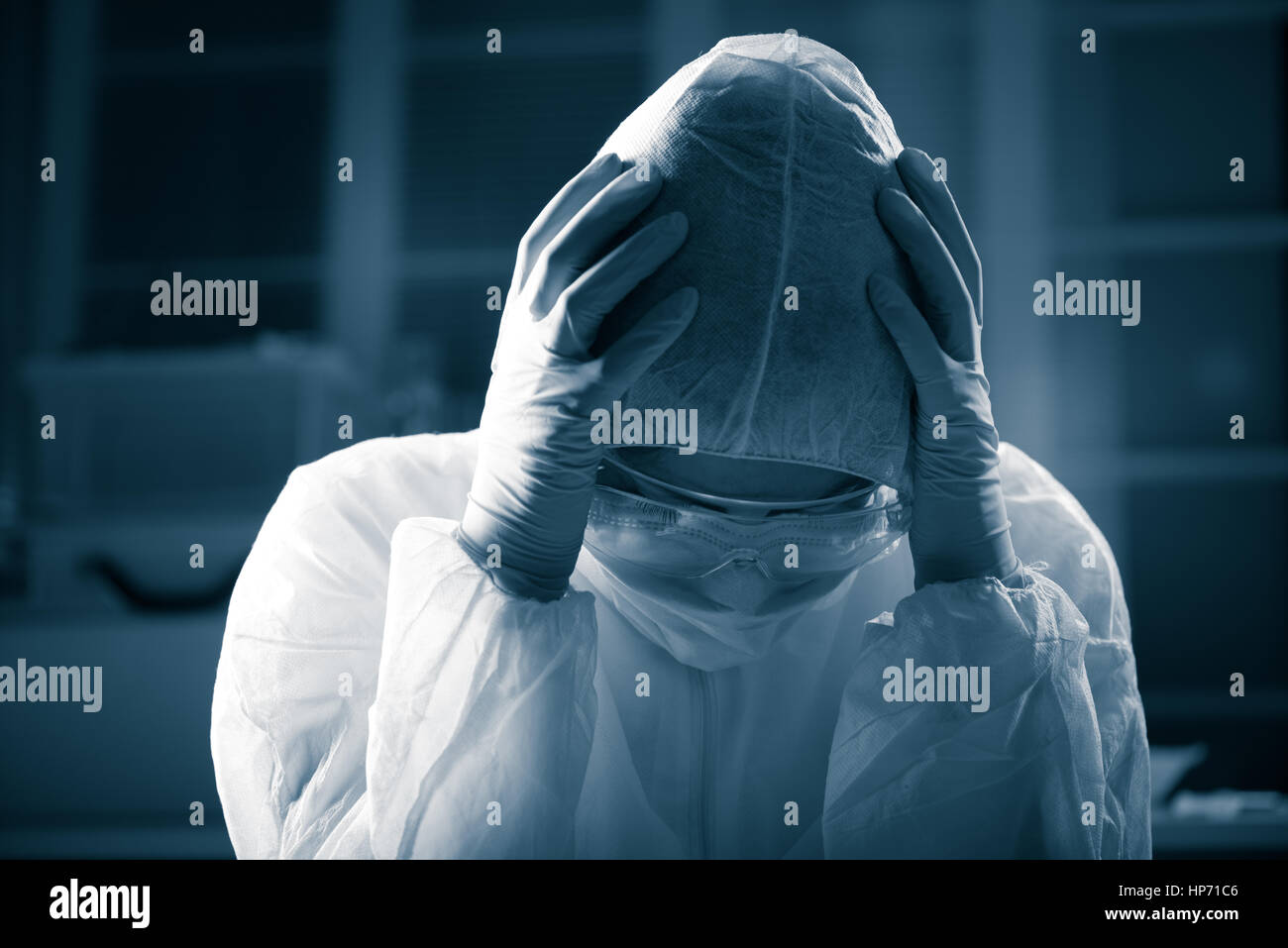 Scientifique terrifiés head in hands wearing hazmat de protection appropriées. Banque D'Images