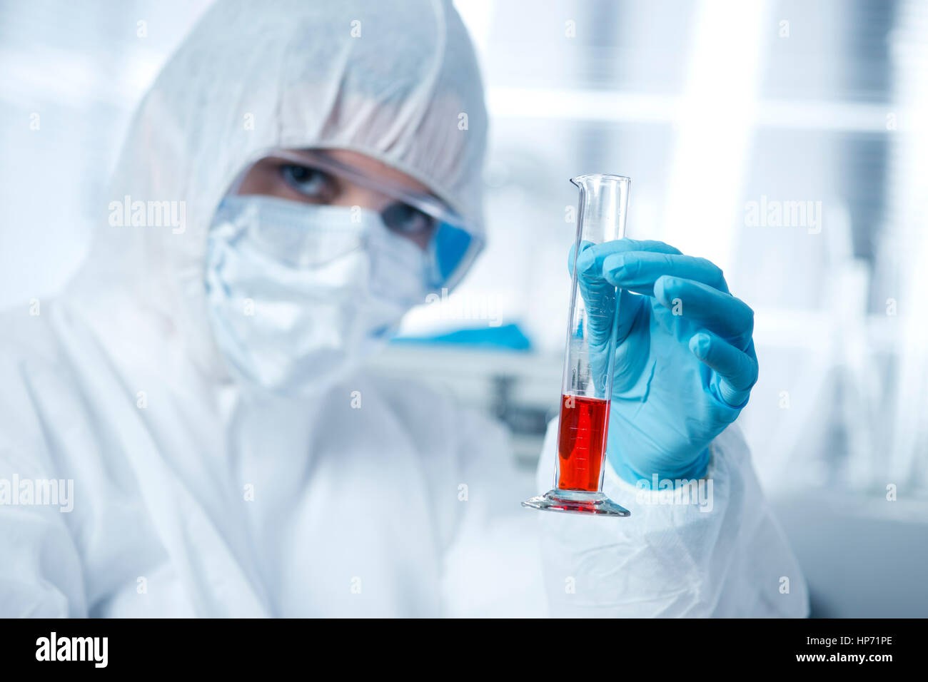 Chercheur en tenue de protection contre les matières dangereuses de l'examen d'un tube à essai dans le laboratoire chimique. Banque D'Images