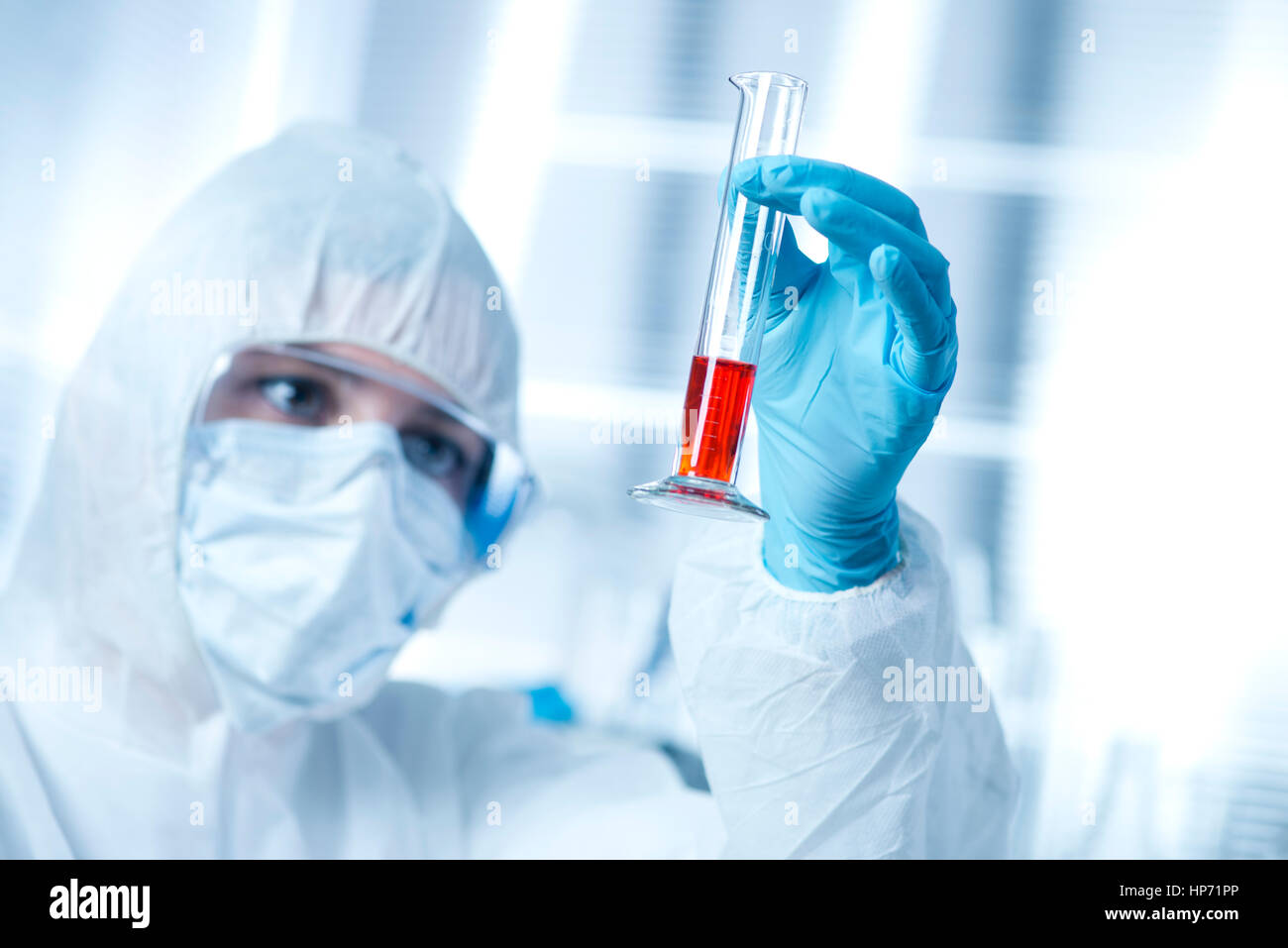 Chercheur en tenue de protection contre les matières dangereuses de l'examen d'un tube à essai dans le laboratoire chimique. Banque D'Images