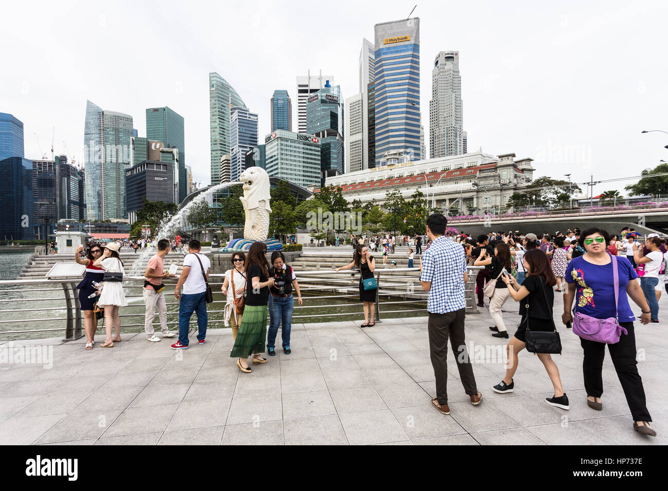 Singapour, Singapour - Septembre 21, 2016 : les touristes de prendre des photos en face de la célèbre skyline de Singapour et la statue du Merlion dans la Marina Bay. Banque D'Images