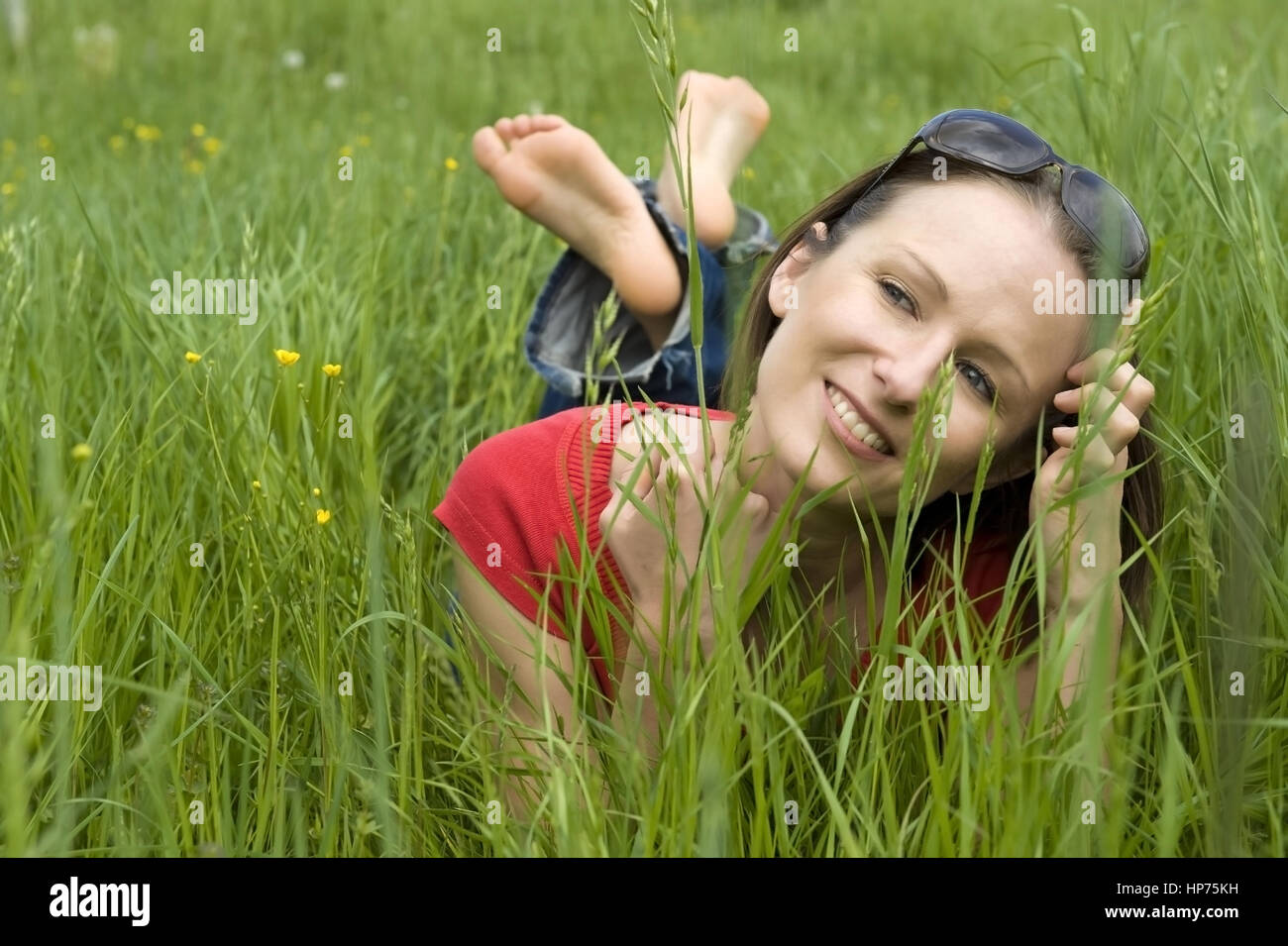 Parution du modèle, Junge Frau, 30, liegt in der entspannt Fruehlingswiese - woman relaxing in spring meadow Banque D'Images