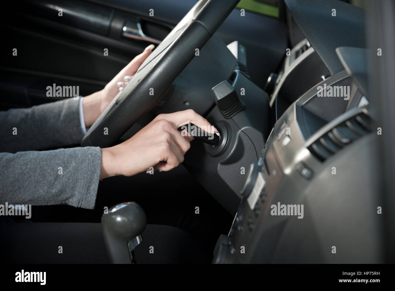 Main femme pilote l'insertion de clé de voiture et de démarrer le moteur. Banque D'Images