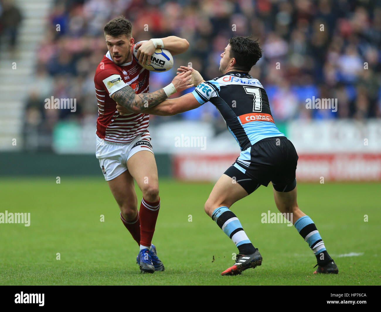 Wigan Warriors' Oliver Gildart est abordé par Cronulla-Sutherland Sharks' Chad Townsend au cours de la Dacia 2017 World Club Series match au DW Stadium, Wigan. Banque D'Images