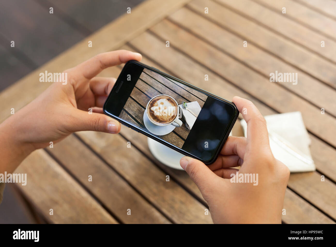 Close-up hand holding mobile phone photo prise sur la table de café Banque D'Images