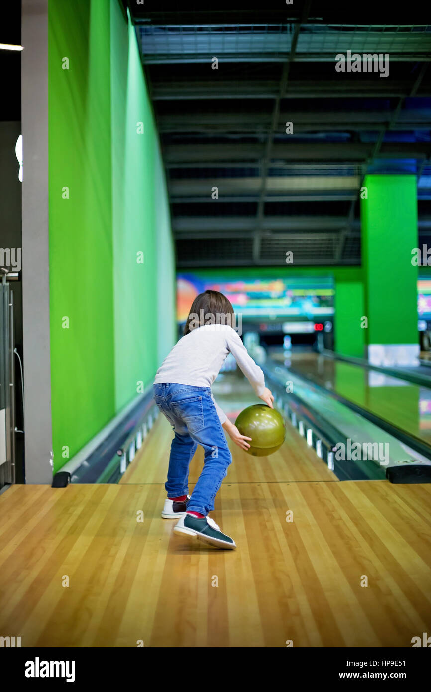 Jeune garçon, jouer au bowling pour la première fois, à l'intérieur Banque D'Images