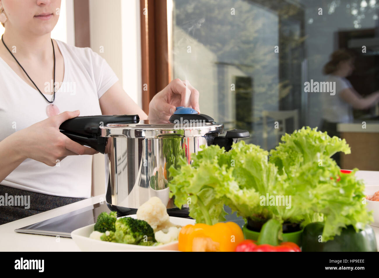 Femme utilise autocuiseur pour cuire un repas. La conception d'une alimentation saine. Banque D'Images
