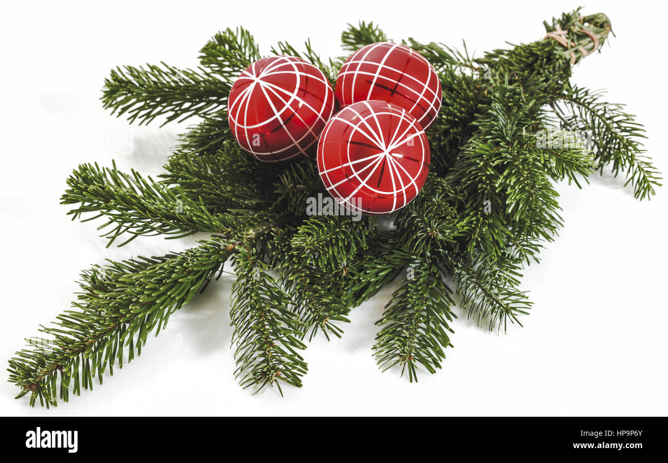 Drei rote christbaumkugeln auf tannenzweigen Banque D'Images