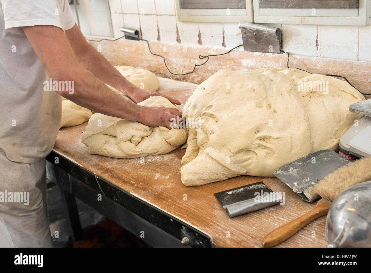 Homme baker mains pétrissant la pâte pour la fabrication du pain dans une boulangerie Banque D'Images