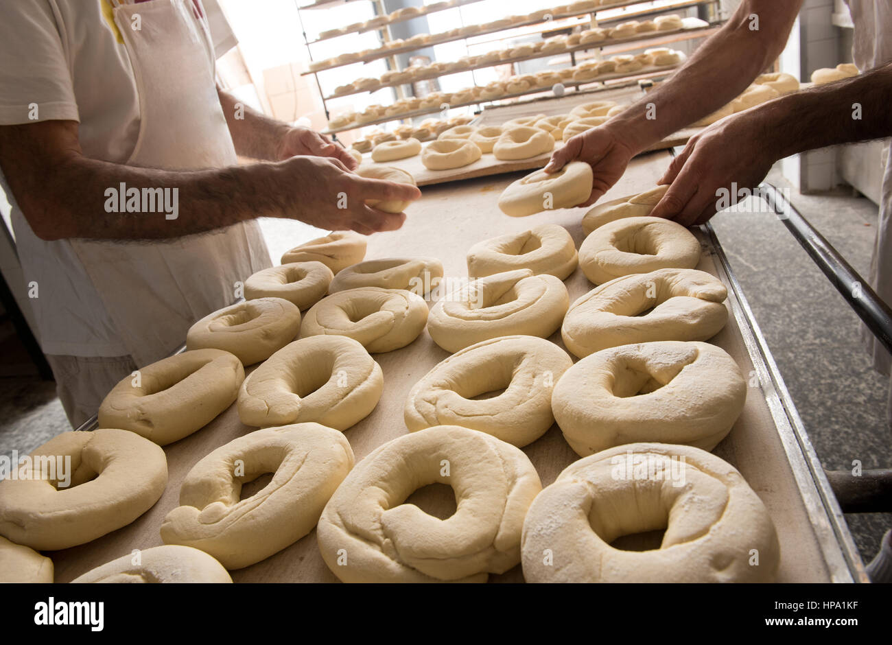 Image en gros plan d'hommes incognito mains boulangers faire des beignets de pâte pour la cuisson du pain frisella la cuisine italienne Banque D'Images