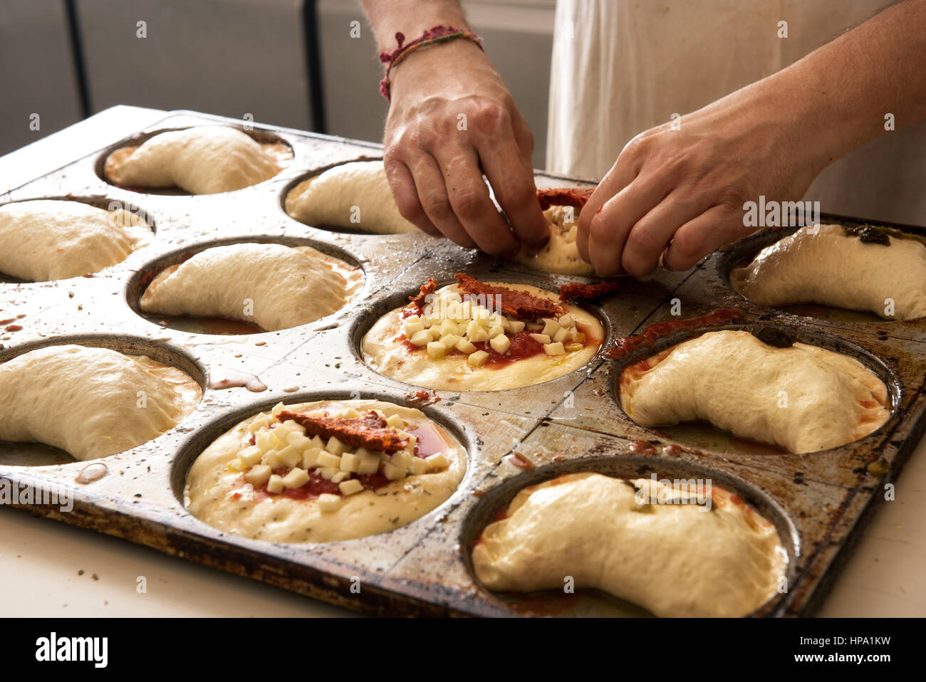 La cuisine italienne male chef mains en close-up pizza et panzerotti pizza fraîche du métal sur la plaque de cuisson Banque D'Images