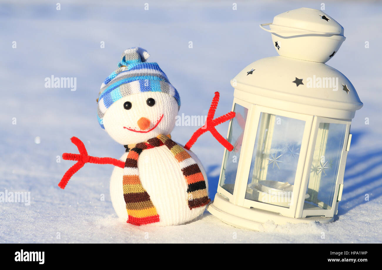 Bougies décoratives et bonhomme de neige sur la neige. Fond d'hiver enneigé. Arrière-plan de la Saint Valentin. Banque D'Images