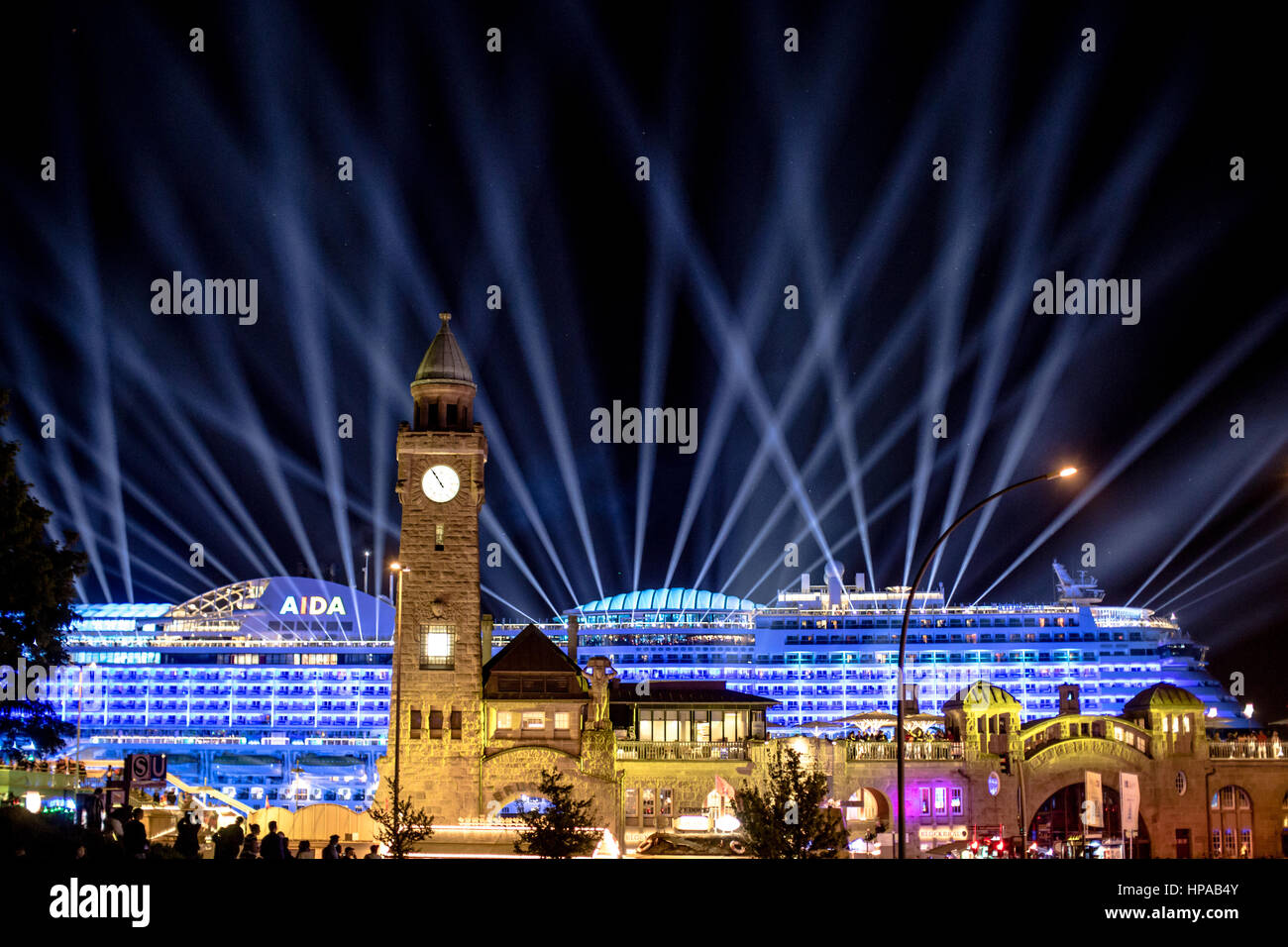 Un très grand navire passant les Landungsbrücken de nuit avec beaucoup de lumière avec l'Towerbar et son horloge à l'avant-plan. Anniversaire du port 2016. Un Banque D'Images