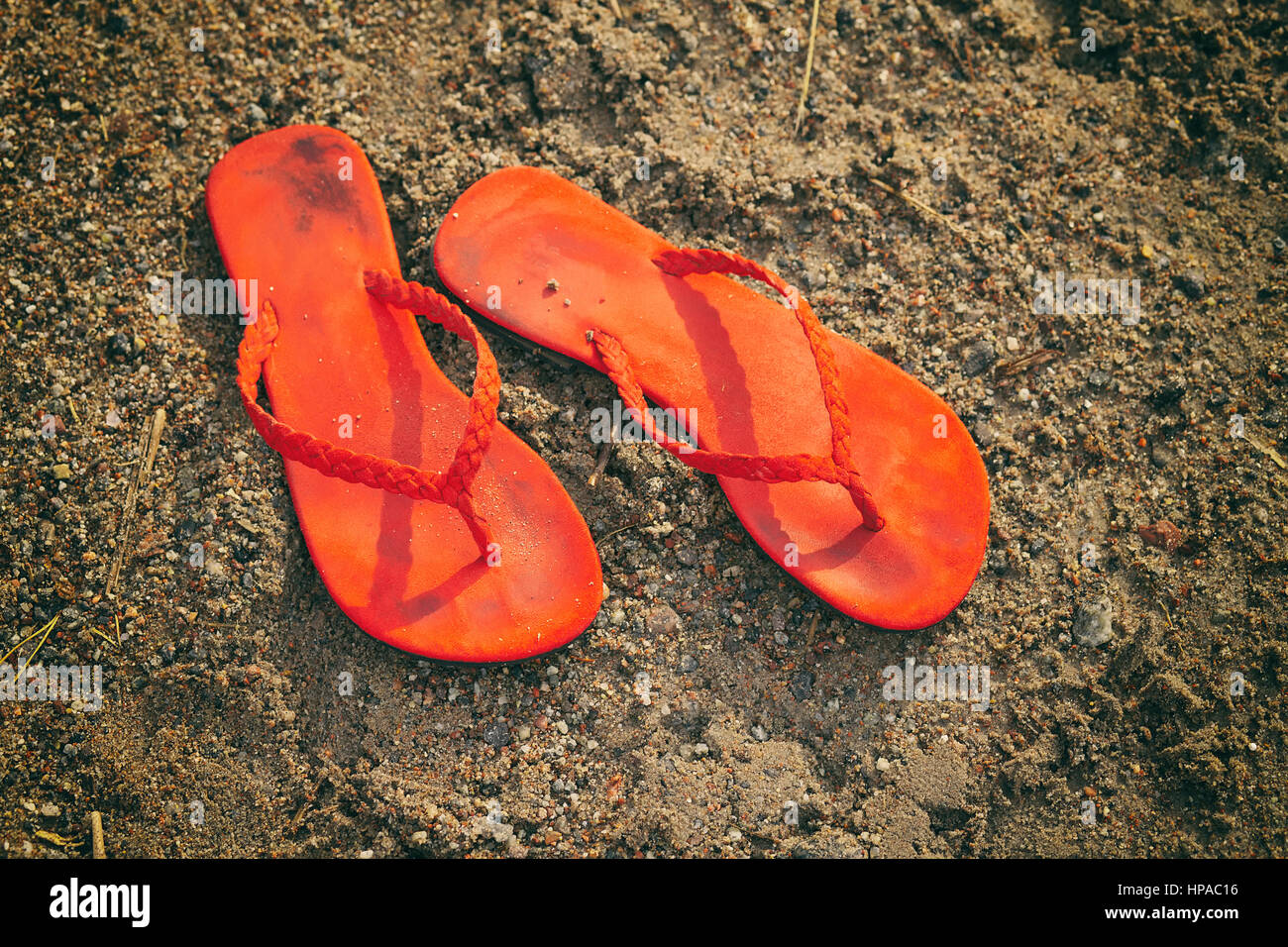 Paire de tongs sur la plage sous le soleil de l'après-midi. Banque D'Images