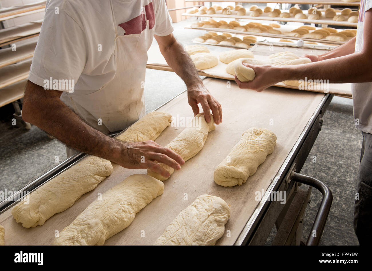 Mettre les mains des boulangers pâte à une bande pour four professionnel en boulangerie pour cuire le pain Banque D'Images