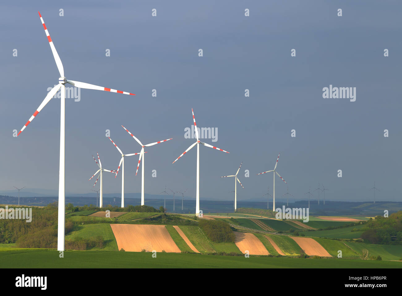 Groupe d'éoliennes sur fond de ciel bleu. Concept d'économiseur d'énergie parfaite. Blanc électrique éoliennes dans la lumière du soleil du soir. Espace libre pour le texte Banque D'Images