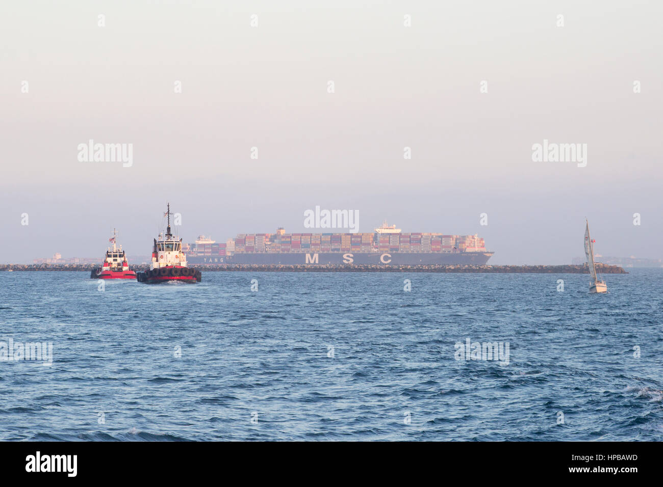 Les remorqueurs retour d'escorter un navire porte-conteneurs MSC sortir du port Banque D'Images
