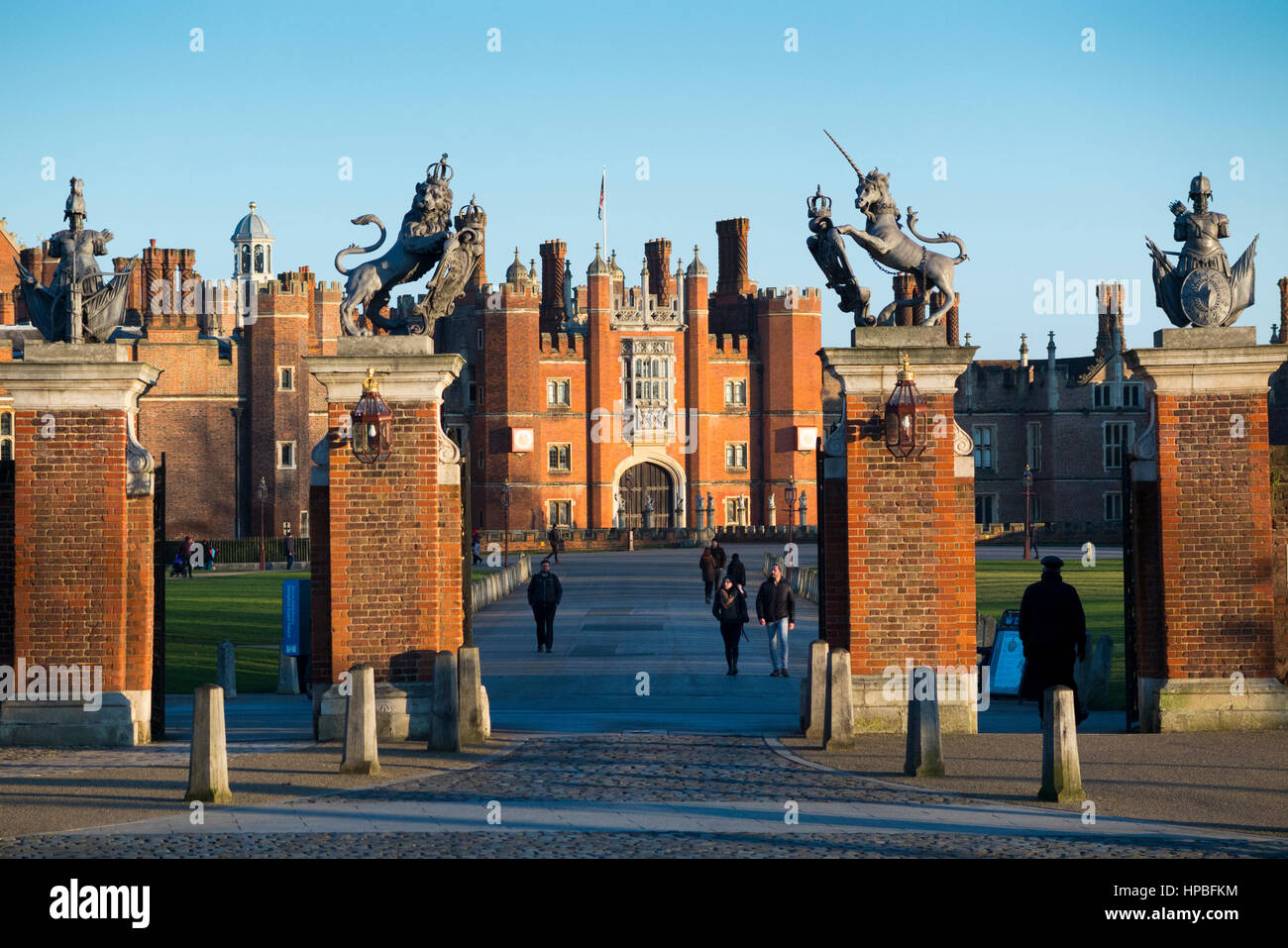 Le Palais de Hampton Court : Entrée principale avec porte posts et dur menant à la porterie, à l'Ouest, avant de le palais ; ciel bleu et soleil. UK. Banque D'Images