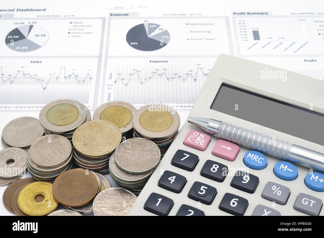 Calculatrice et pile de pièces sur du papier blanc de graphique financier Banque D'Images