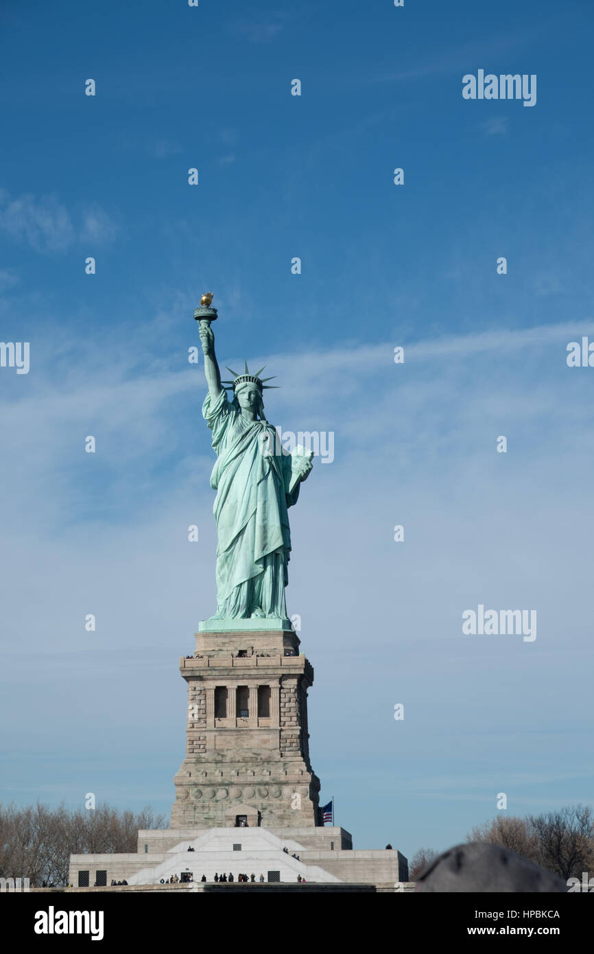 Statue de la liberté sur son piédestal. Statue de la liberté qui donne sur le port de New York sur une journée ensoleillée avec un ciel bleu et des nuages filandreux. Liberty Island, New Yor Banque D'Images