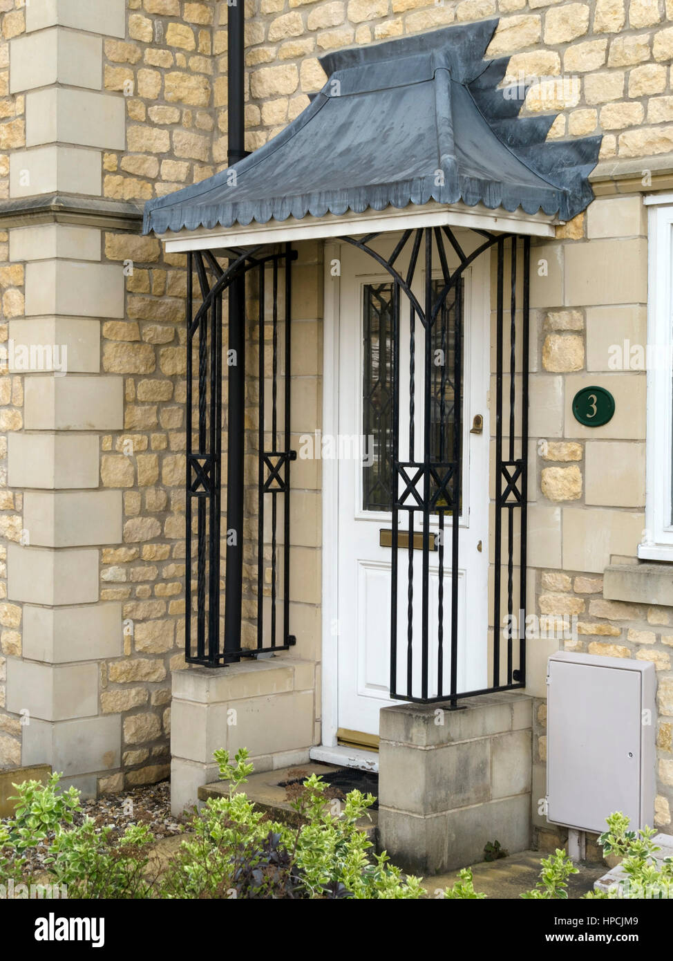 Chambre avec porte en fer forgé garde-corps ornemental porche et auvent toit flashé, UK Banque D'Images