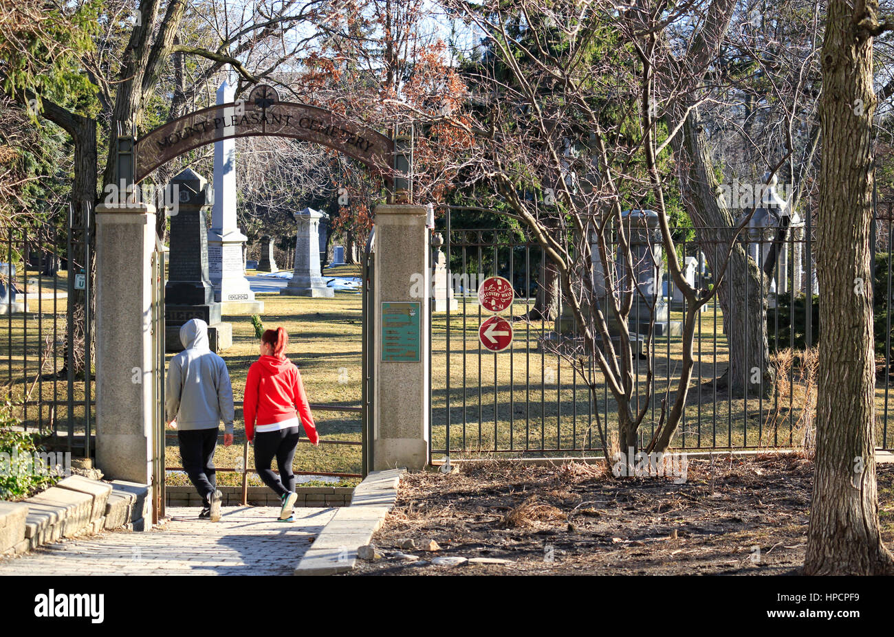 Deux personnes yonge marche à vive allure sur Disvery à pied dans le cimetière Mount Pleasant historique à partir de la ceinture de Trail à Toronto, Ontario, Canada, sous le soleil da Banque D'Images