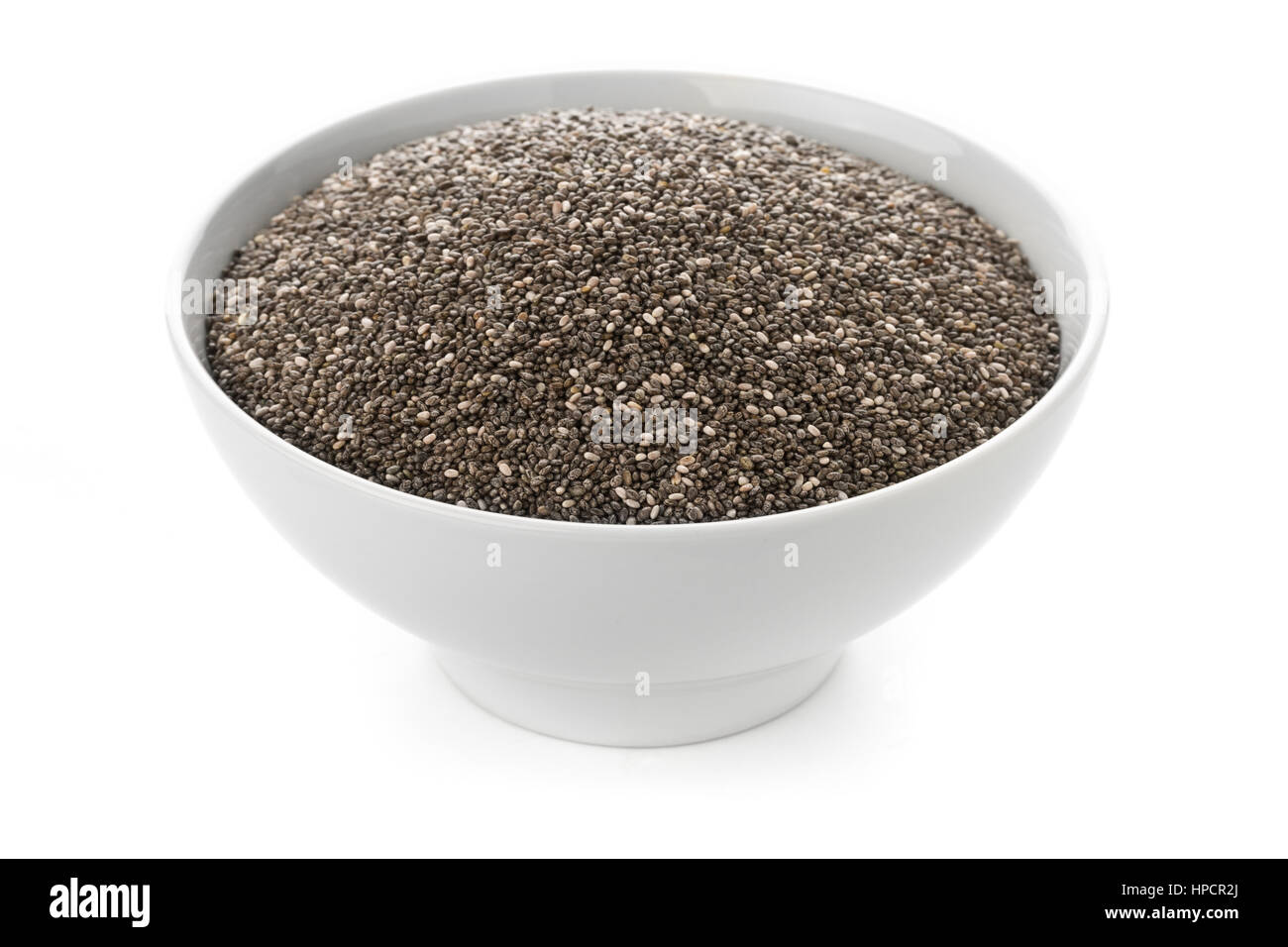 Matières et à l'état brut, les graines de chia noir en boule blanche sur fond blanc Banque D'Images
