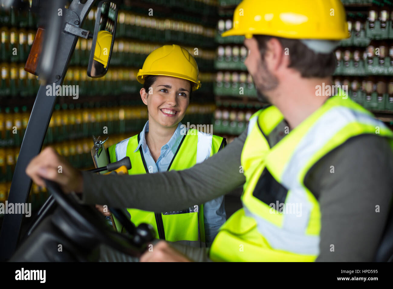 Smiling les ouvriers d'usine en interaction les uns avec les autres en usine Banque D'Images