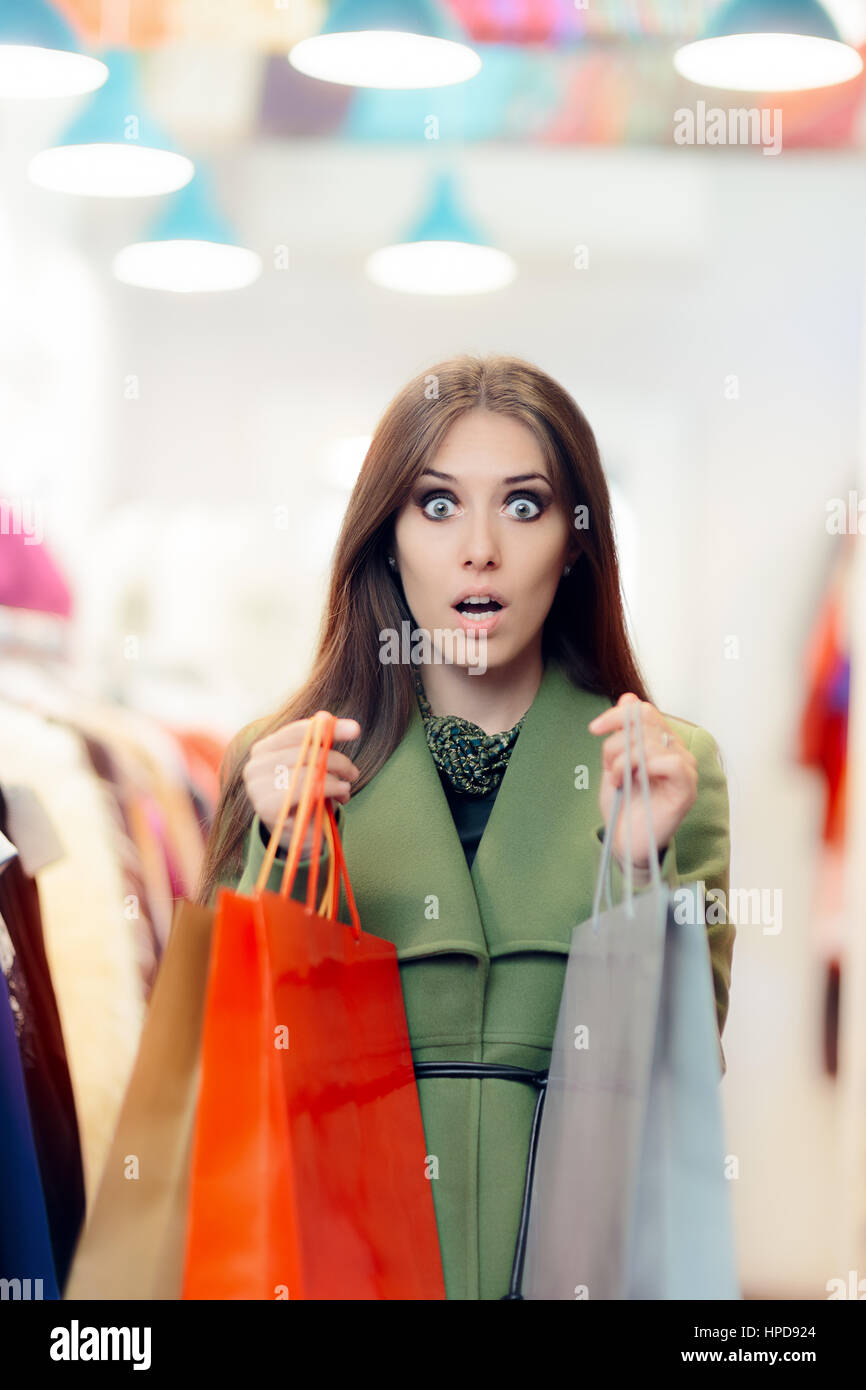 Surpris Shopping femme portant un manteau vert à la mode Store Banque D'Images