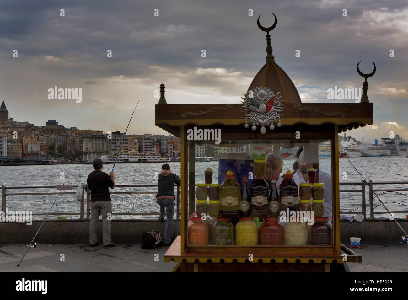 Les pêcheurs et de blocage de l'alimentation sur la Corne d'or, dans le district d'Eminonu près de pont de Galata, en arrière-plan quartier de Beyoglu, Istanbul. La Turquie Banque D'Images