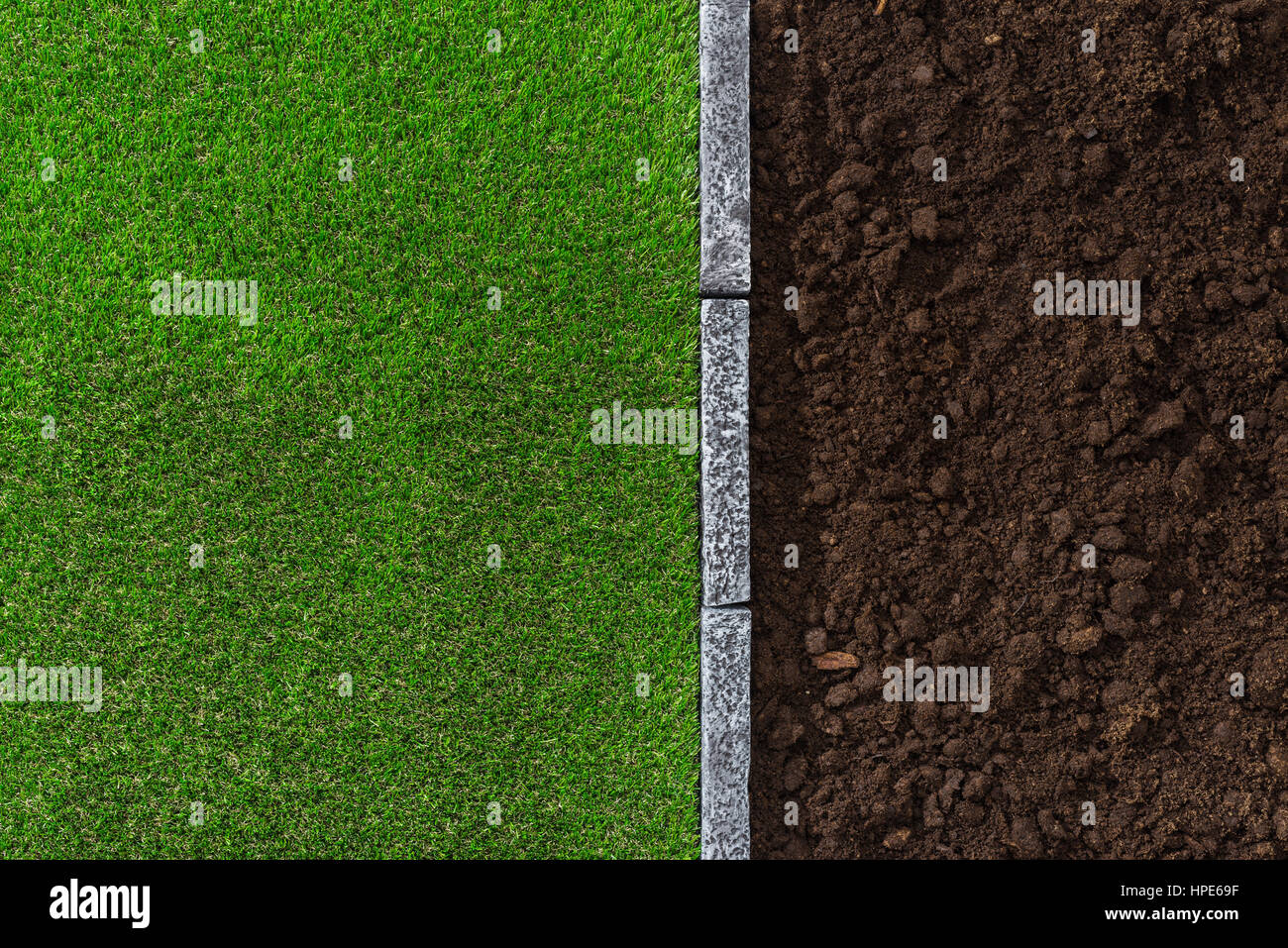 L'humus fertile le sol et l'herbe luxuriante divisé par une bordure en pierre, le jardinage et l'aménagement paysager Concept Banque D'Images