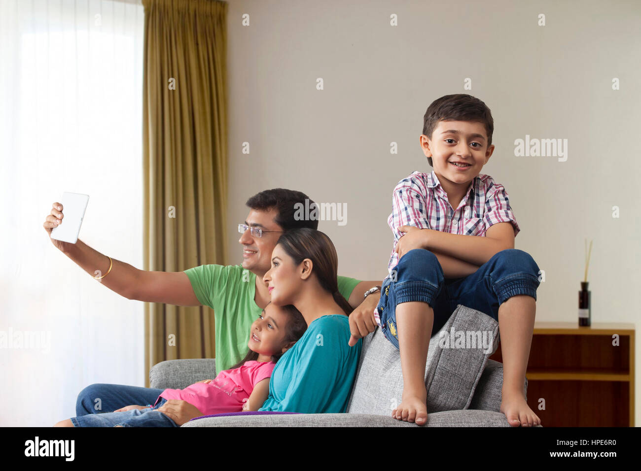 Portrait of smiling boy avec ses parents et sa sœur à l'aide de tablette numérique à l'arrière-plan Banque D'Images