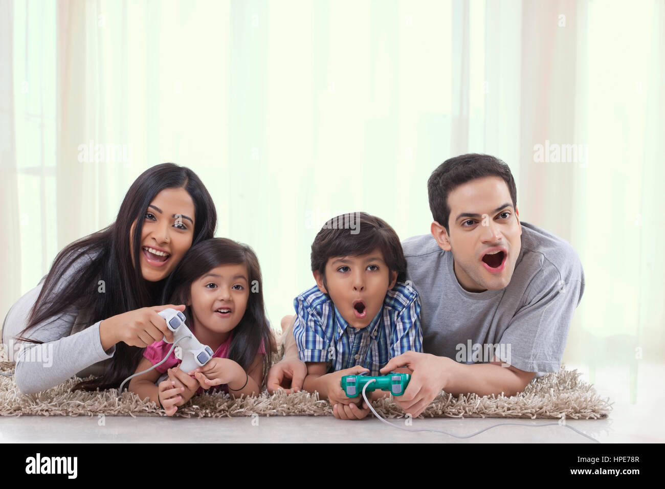 Jeune famille à jouer avec une console de jeu Banque D'Images