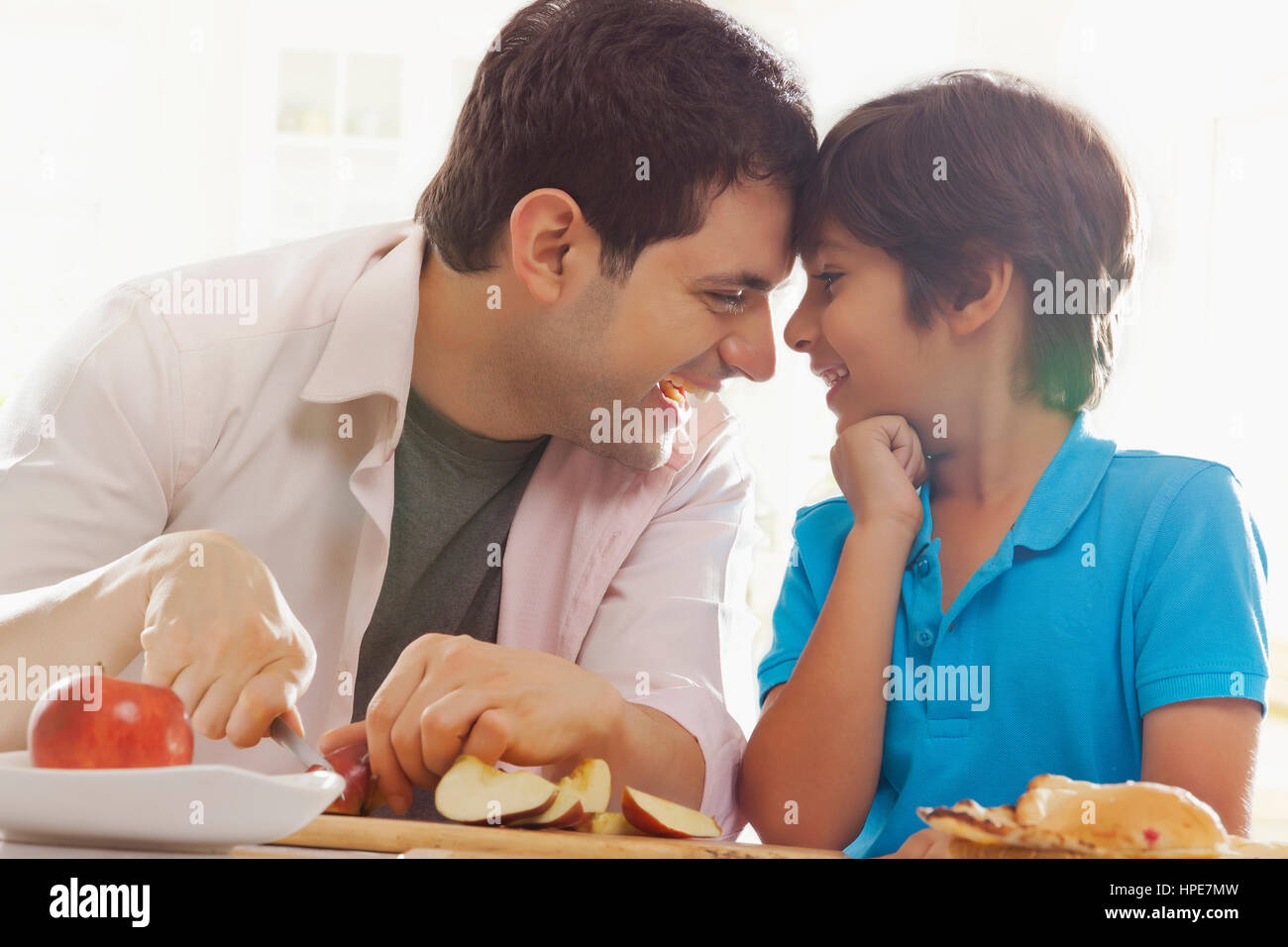 Heureux père et son fils avec les chefs ensemble à table du petit déjeuner Banque D'Images