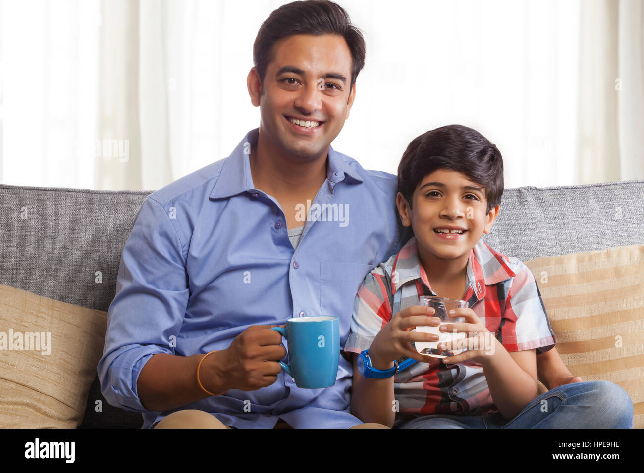 Boy boire du jus avec son père Banque D'Images