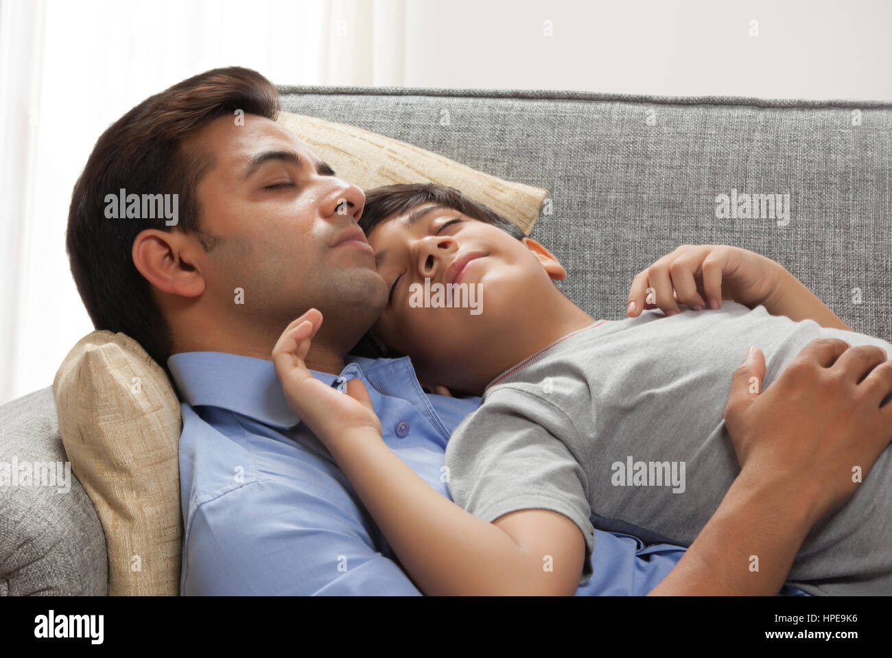 Père et fils dormir sur canapé Banque D'Images