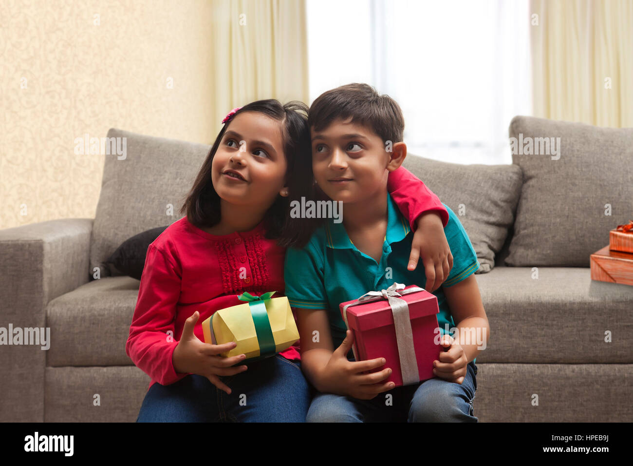 Brother and sister holding présente dans la salle de séjour Banque D'Images